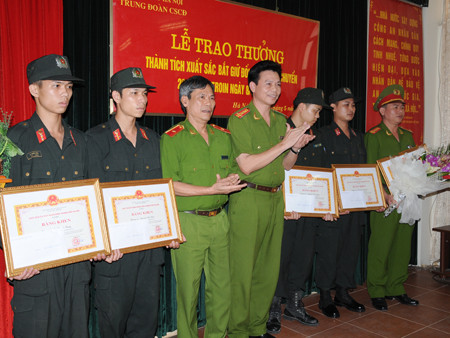 Thiếu tướng Trần Thùy - Phó Giám đố CATP Hà Nội (thứ ba, từ trái qua) trao thưởng cho các cán bộ, chiến sĩ trong Đại đội 12 đã xuất sắc bắt giữ hai đối tượng, thu 26 bánh heroin