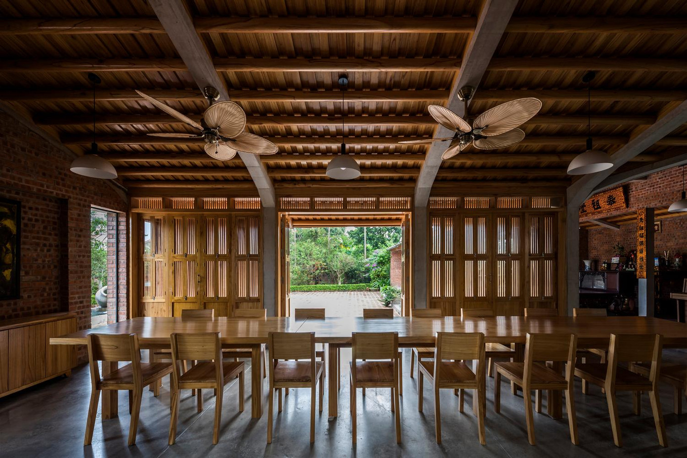 Ngôi nhà có sức chứa cho một đại gia đình khi có không gian bàn thờ - không gian thờ cúng trang trọng trong các ngôi nhà Việt, là nét văn hóa truyền thống trong vùng. Tại tầng 1, không gian bàn thờ và phòng ăn liên kết với nhau và thông ra khoảng sân trung tâm phía trước để mọi người có thể di chuyển hoặc mở rộng sinh hoạt. Sân trước đóng vai trò quan trọng đối với lối ra vào nhà. Phòng thờ cùng với phòng khách - phòng ăn lớn có thể thông ra sân trung tâm, cho phép người ở di chuyển dễ dàng và tự do tại tầng trệt. Các tiện ích như nhà bếp, khu để đồ và hai phòng ngủ chính được bố trí ở mặt sau của ngôi nhà. Ba phòng khách được đặt ở tầng thứ hai, nơi người ở có thể nhìn ra thảm thực vật tươi tốt xung quanh. Hệ thống cửa được thiết kế linh hoạt, đóng mở theo từng phần riêng biệt, đáp ứng nhu cầu và sở thích của gia đình. Hơn nữa, mỗi cánh cửa đều có một cửa sổ nhỏ có thể mở ra để kiểm soát không khí và ánh sáng bên trong một cách hiệu quả. Sân vườn của nhà được thiết kế theo hình zíc zắc để tối đa hoá trải nghiệm thưởng ngoạn cảnh quan nông thôn; cũng như giúp không khí được lưu thông ở cả trong nhà và ngoài trời. Chất liệu tường và sân được sử dụng gạch đỏ lộ thiên, loại vật liệu bình dân nhưng tạo nên sự ấm cúng cho cảnh quan. Cây trồng trong vườn cũng được chọn từ những cây địa phương.