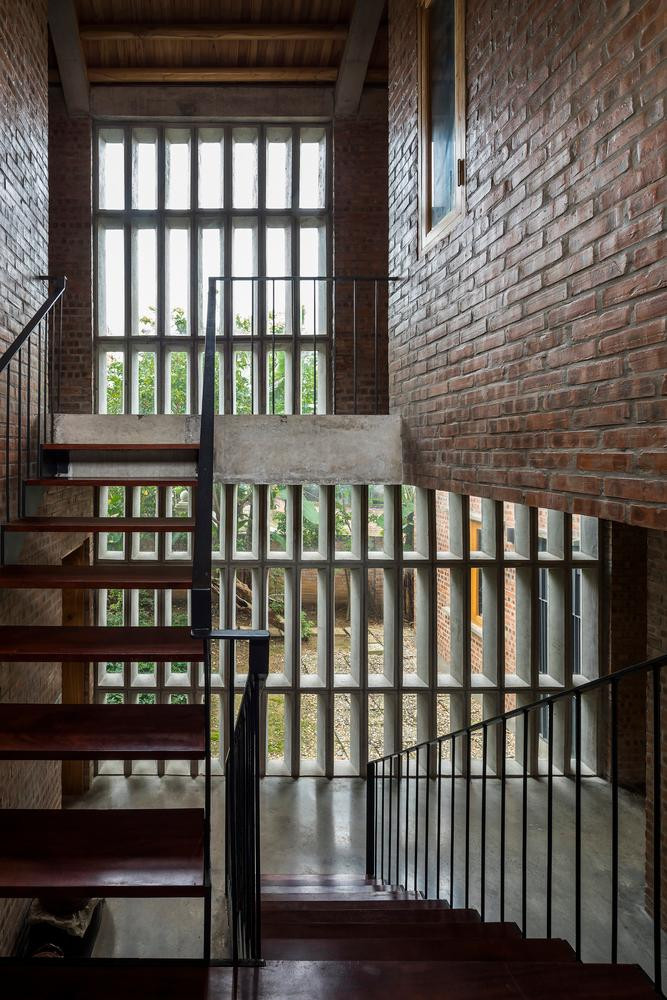 Ba phòng khách được đặt ở tầng thứ hai, nơi người ở có thể nhìn ra thảm thực vật tươi tốt xung quanh. Hệ thống cửa được thiết kế linh hoạt, đóng mở theo từng phần riêng biệt, đáp ứng nhu cầu và sở thích của gia đình. Hơn nữa, mỗi cánh cửa đều có một cửa sổ nhỏ có thể mở ra để kiểm soát không khí và ánh sáng bên trong một cách hiệu quả.