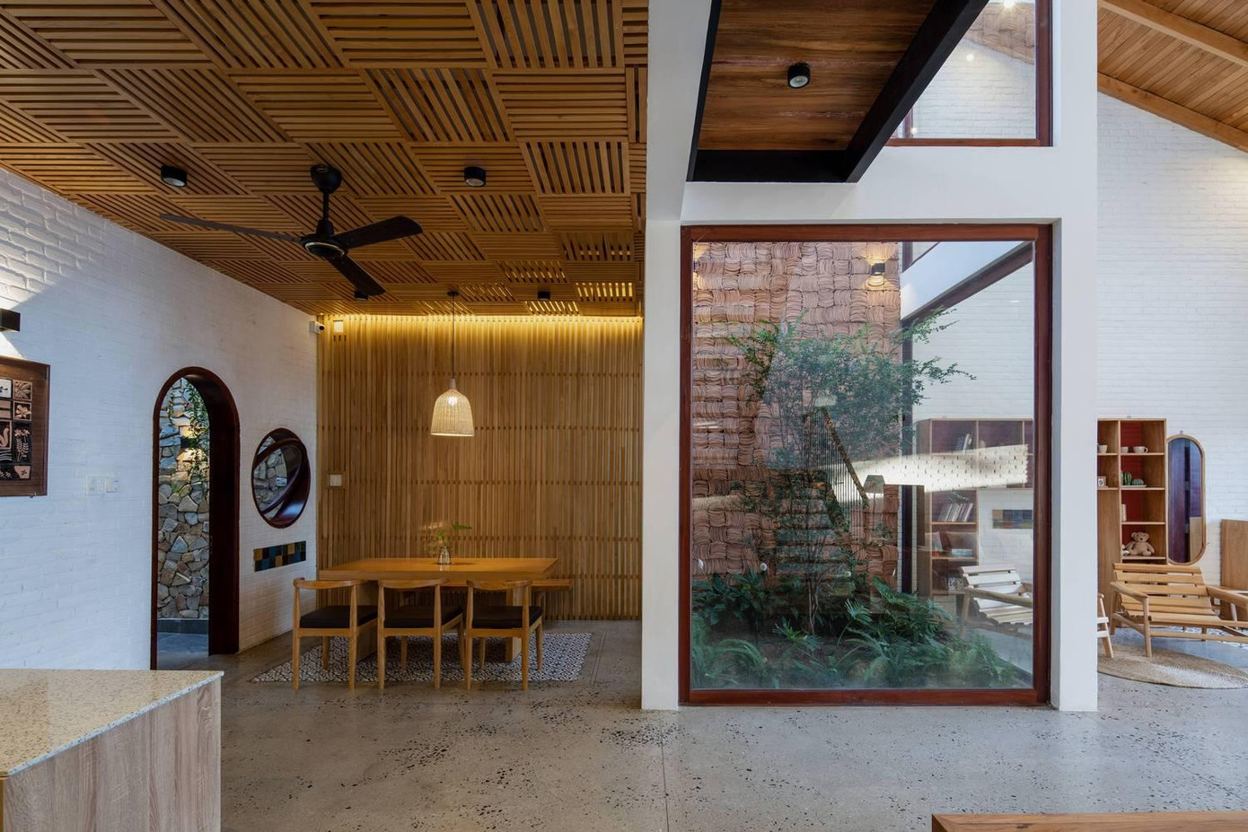 Trong phòng khách, một giếng trời lớn được thiết kế chiếu rọi xuống khu vườn nhỏ trồng cây xanh, bao quanh khu vườn là các tấm kính trong suốt giúp ngôi nhà luôn tràn ngập ánh sáng.