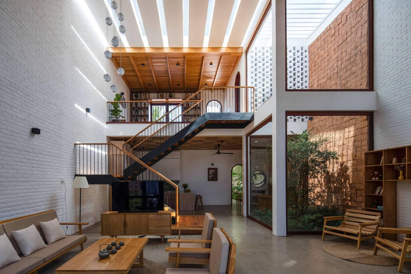 Từ ngoài vào, đầu tiên là khu vực không gian sinh hoạt chung, đây là khoảng thông tầng lớn liên thông với không gian đọc sách và bàn thờ phía trên ở gác lửng.