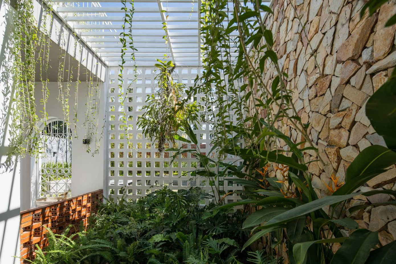 Hệ thống nan gỗ, gạch thông gió, giếng trời giúp các khối chức năng dễ dàng tiếp cận với thiên nhiên mà vẫn đảm bảo sự riêng tư cho từng không gian. Tiếp nối sau khu vực phòng ngủ là một bãi cỏ lớn, nơi vui chơi của trẻ em và có bàn ghế cho người lớn ngồi uống trà. Ngôi nhà kết hợp sử dụng các vật liệu cũ và mới và các vật liệu tự nhiên được xử lý ở mức độ vừa đủ để không làm mất đi bầu không khí vốn có của chúng. Sự kết nối của hiện tại, quá khứ và tương lai, giữa con người với con người, con người với môi trường xung quanh là giá trị cốt lõi mà dự án cố gắng đạt được.