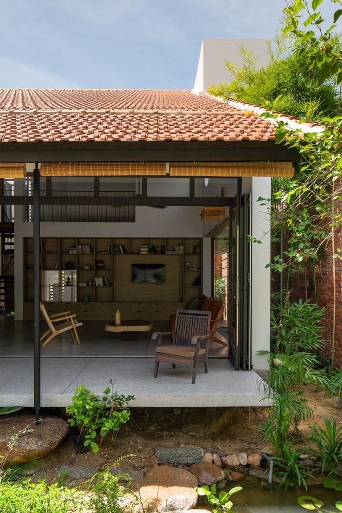 Việc thiết kế cao độ cho ngôi nhà được nghiên cứu và tính toán kỹ lưỡng khi thời tiết khắc nghiệt gây ngập lụt hàng năm ngày một nhiều nhưng vẫn phải tuân theo quy hoạch chung của thành phố. Công trình sử dụng mái ngói để giữ cho trong nhà luôn mát mẻ và mang nét truyền thống của văn hóa Việt Nam. Không gian nhà để xe ở sân vườn phía trước được nâng lên không quá cao, vừa đủ để đi lại dễ dàng, sau đó không gian nhà chính được nâng lên cao hơn và được chuyển tiếp bằng cầu thang ít bậc, giải pháp này giúp cho toàn bộ không gian chính được an toàn trong mùa mưa bão mà vẫn hài hòa bên trong và bên ngoài của ngôi nhà. Ngoài ra, các góc nhìn từ trong ra ngoài và từ ngoài vào trong cũng thú vị hơn. Việc thiết kế cao độ cho ngôi nhà được nghiên cứu và tính toán kỹ lưỡng khi thời tiết khắc nghiệt gây ngập lụt hàng năm ngày một nhiều nhưng vẫn phải tuân theo quy hoạch chung của thành phố. Công trình sử dụng mái ngói để giữ cho trong nhà luôn mát mẻ và mang nét truyền thống của văn hóa Việt Nam. Không gian nhà để xe ở sân vườn phía trước được nâng lên không quá cao, vừa đủ để đi lại dễ dàng, sau đó không gian nhà chính được nâng lên cao hơn và được chuyển tiếp bằng cầu thang ít bậc, giải pháp này giúp cho toàn bộ không gian chính được an toàn trong mùa mưa bão mà vẫn hài hòa bên trong và bên ngoài của ngôi nhà. Ngoài ra, các góc nhìn từ trong ra ngoài và từ ngoài vào trong cũng thú vị hơn.