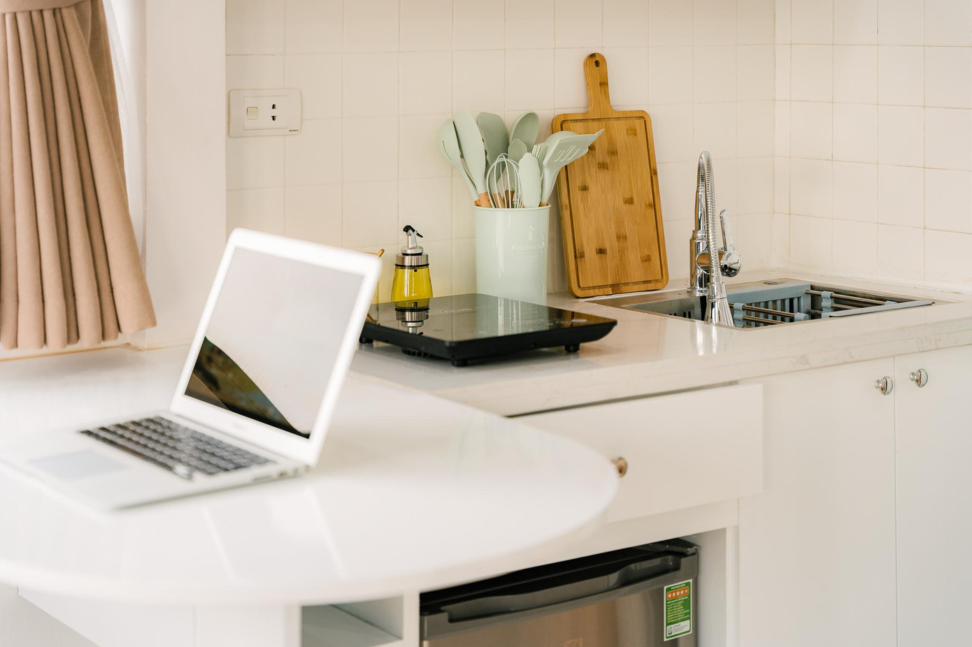 Bàn quầy bar có thể gập xuống bằng mặt bếp. Ngăn tủ mini bên dưới tăng không gian để đồ và đỡ mặt bàn.