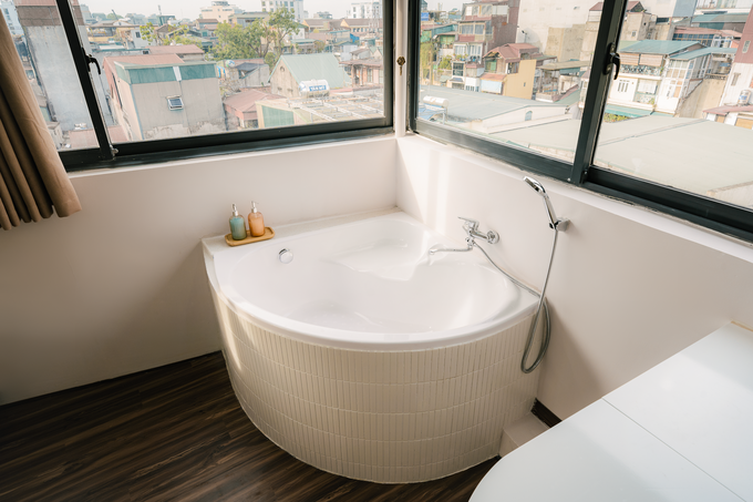 Bồn tắm để ngâm mình thư giãn và sàn bằng nhựa giả gỗ nên gia chủ không lo ướt phòng.