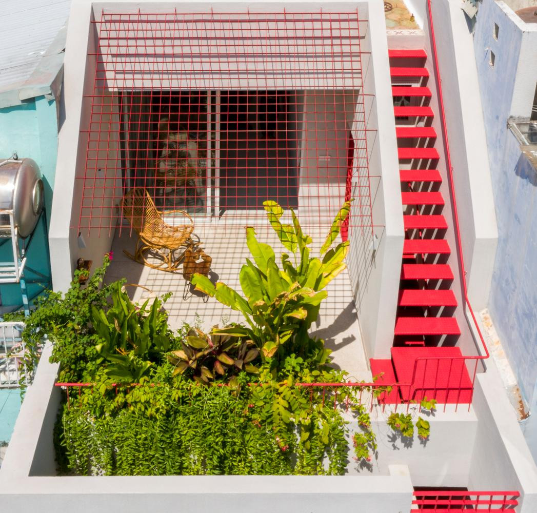 Sử dụng các thanh nan sắt hình chữ nhật màu đỏ với đủ kích thước kết hợp với màu sơn ngoại thất trắng để làm mặt tiền khiến ngôi nhà có điểm nhấn và lưu thông không khí một cách tốt nhất. Bên cạnh đó, thay vì làm cầu thang dẫn lên sân thượng trong nhà hoặc ở phía sau thì có thể chuyển nó lên mặt tiền, trồng thêm cây xanh hoặc dây leo trên tầng áp mái để tăng thêm phần xinh xắn cho ngôi nhà. Công trình này ở Hòa Xuân (Đà Nẵng) có mặt tiền tầng 2 và tầng 3 lùi về phía sau để làm khu vườn trên tầng trệt thay vì ở tầng cao nhất của ngôi nhà như thông thường, sử dụng các thanh nan màu trắng tạo sự dịu dàng cho khu vườn kết hợp với phần mái vòm cao ở tầng 2 và 3 khiến cho mặt tiền giống như khu vườn địa đàng trong truyện cổ tích. Sử dụng các thanh nan sắt hình chữ nhật màu đỏ với đủ kích thước kết hợp với màu sơn ngoại thất trắng để làm mặt tiền khiến ngôi nhà có điểm nhấn và lưu thông không khí một cách tốt nhất. Bên cạnh đó, thay vì làm cầu thang dẫn lên sân thượng trong nhà hoặc ở phía sau thì có thể chuyển nó lên mặt tiền, trồng thêm cây xanh hoặc dây leo trên tầng áp mái để tăng thêm phần xinh xắn cho ngôi nhà. Công trình này ở Hòa Xuân (Đà Nẵng) có mặt tiền tầng 2 và tầng 3 lùi về phía sau để làm khu vườn trên tầng trệt thay vì ở tầng cao nhất của ngôi nhà như thông thường, sử dụng các thanh nan màu trắng tạo sự dịu dàng cho khu vườn kết hợp với phần mái vòm cao ở tầng 2 và 3 khiến cho mặt tiền giống như khu vườn địa đàng trong truyện cổ tích.