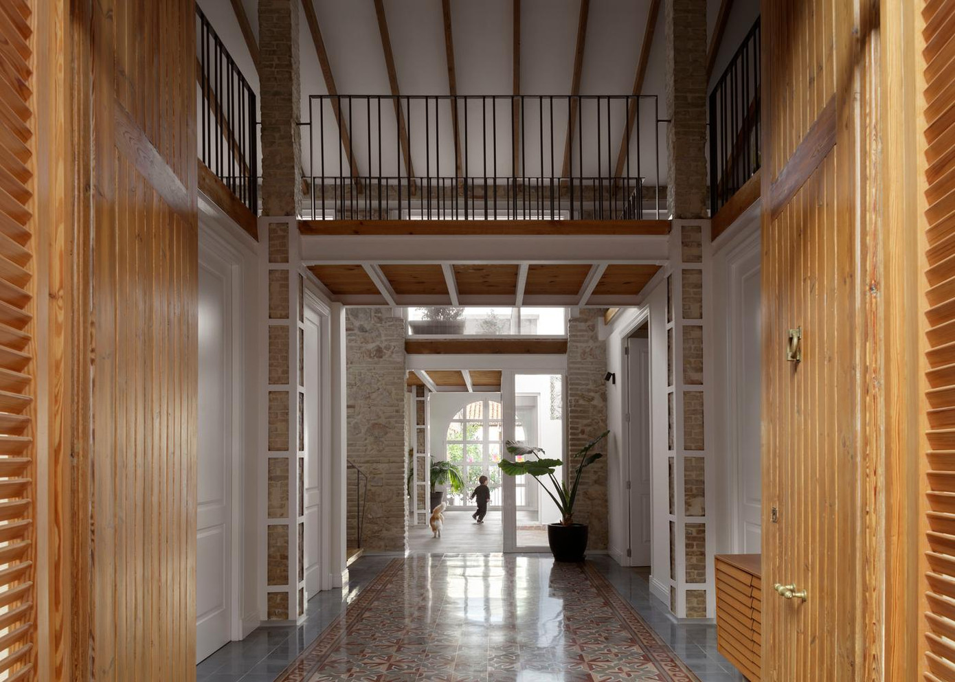 Ngôi nhà có hai cửa, cửa chính bằng gỗ ở mặt tiền, còn cửa sau bằng kính ở mặt phía sau; hai cửa đối diện nhau nên nếu mở cửa chính bạn sẽ nhìn thấy cửa sau luôn, việc này tạo cảm giác đa chiều cho không gian. Ngay cửa là hai phòng ngủ có view nhìn ra đường, bên trên không gian này là gác lửng.