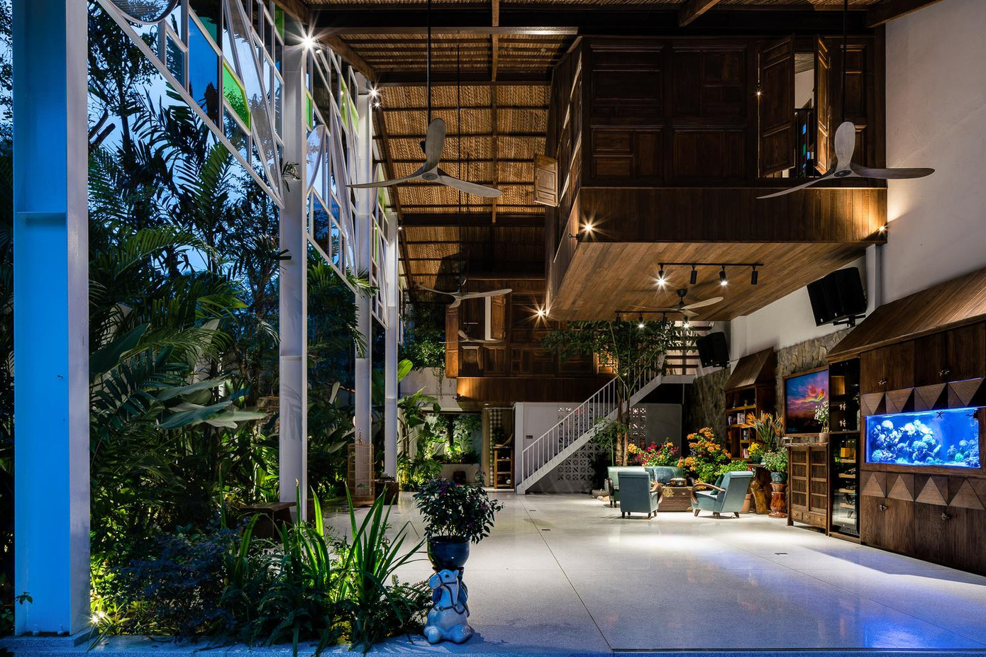 Tầng trệt thông thoáng trở thành không gian đa năng. Đây không chỉ là nơi thờ cúng tổ tiên mà còn là sân chơi cho con cái; mỗi buổi chiều chủ nhà có thể mời bạn bè của mình đến chơi bóng bàn và ăn tiệc vào buổi tối.