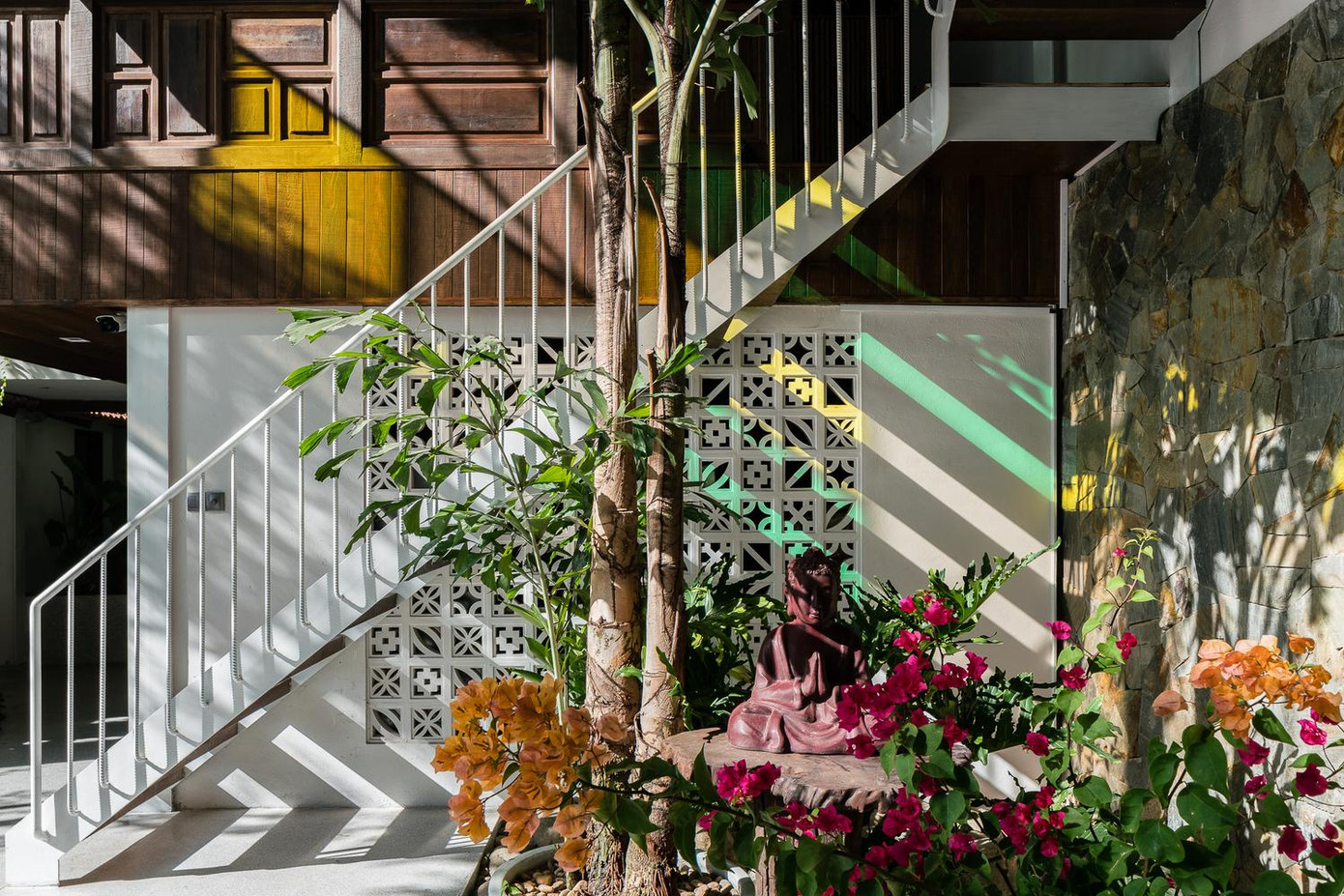 Nhìn bao quát phòng khách là khu vườn lớn, góc không gian thờ cúng có ánh nắng xuyên qua những ô kính nhiều màu sắc tạo cảm giác thoát tục.