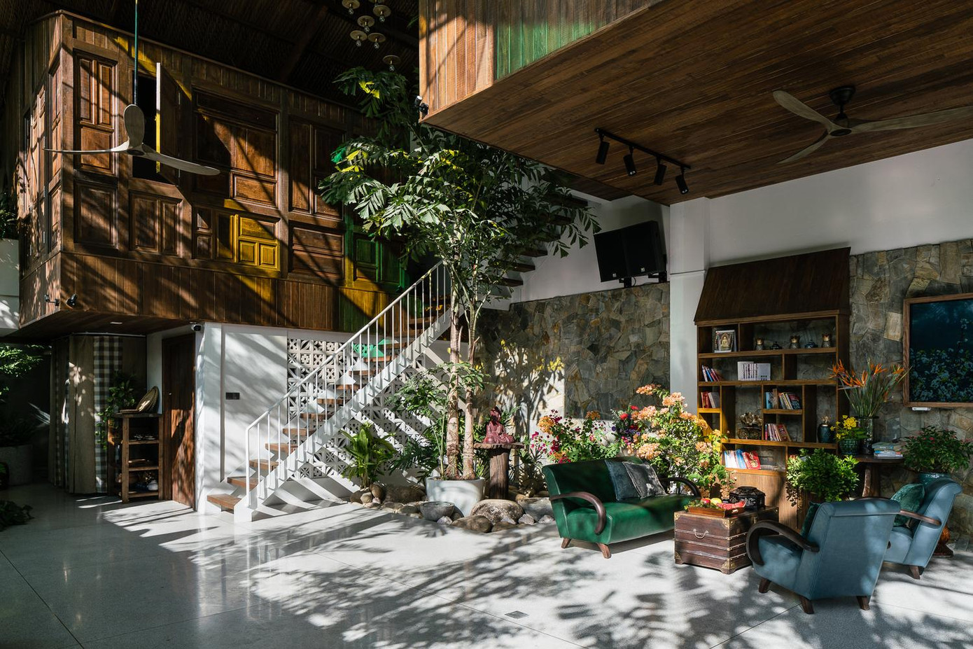 Nhìn bao quát phòng khách là khu vườn lớn, góc không gian thờ cúng có ánh nắng xuyên qua những ô kính nhiều màu sắc tạo cảm giác thoát tục. Hai phòng ngủ kiểu bungalow áp mái được treo phía trên không gian tầng trệt như 2 tổ chim yến. Hai phòng ngủ được bày trí như khung cảnh trong khu nghỉ dưỡng với bồn tắm lớn ngoài trời. Mục đích chính của nơi này là để tổ chức các sự kiện như thờ cúng tổ tiên và gắn kết gia đình, bạn bè.