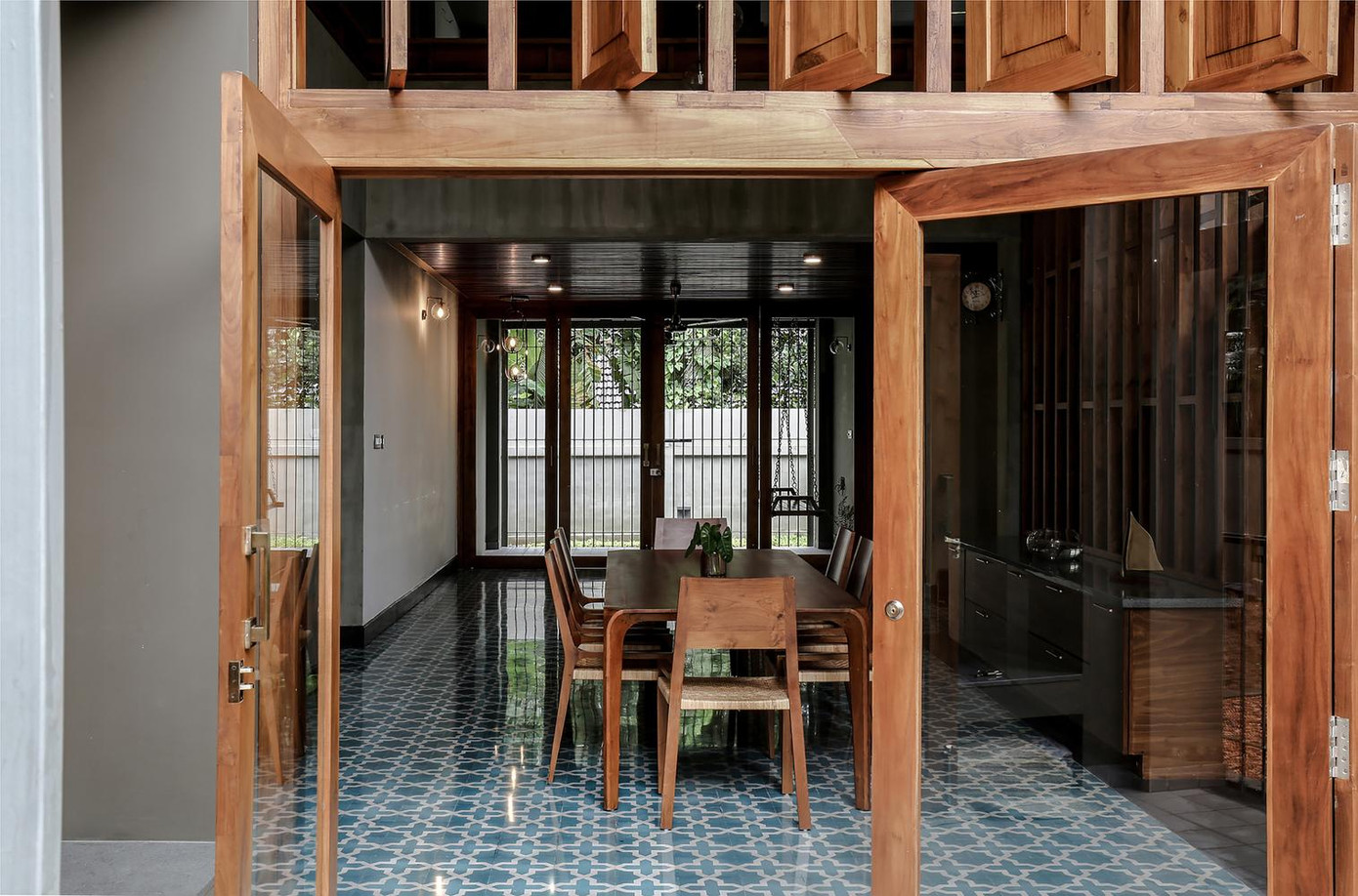 Ở phía bên trái là không gian phòng bếp và phòng ăn. Toàn bộ đồ nội thất đều làm bằng gỗ trong khi các cửa bằng kính để căn nhà luôn tràn ngập ánh sáng.