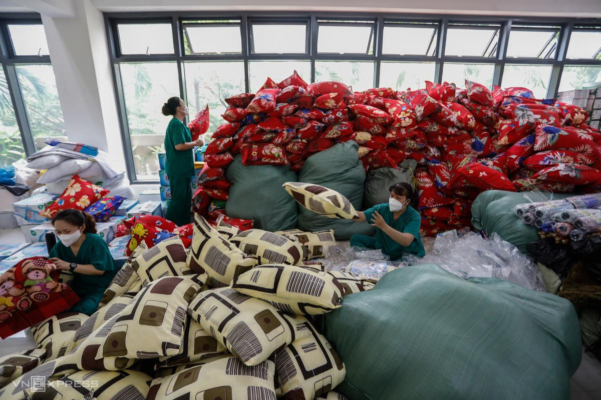 Bên trong bệnh viện, các nhân viên y tế chuẩn bị mền, gối khi các F0 nhập viện. "Ngoài vấn đề dinh dưỡng như ăn uống đủ chất, bệnh nhân Covid cần được chăm sóc giấc ngủ, nghỉ ngơi đầy đủ mới nhanh khỏi bệnh", một điều dưỡng tên Hiền cho biết.