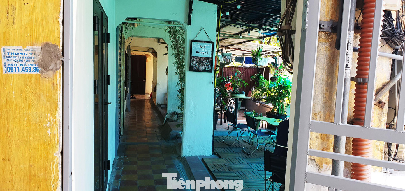 Chủ quán bố trí quầy bar và bàn nhỏ trong nhà, lắp thêm mái che và thiết kế một bàn cao ngoài ban công phía trước căn hộ để khách có thể ngắm cảnh vào buổi tối.