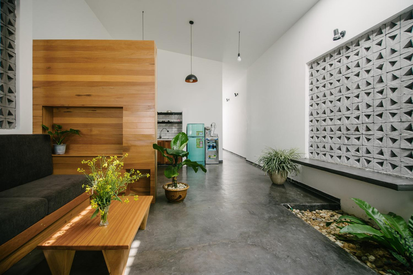 Phòng khách được ngăn cách với bếp bằng một tấm gỗ trang trí.