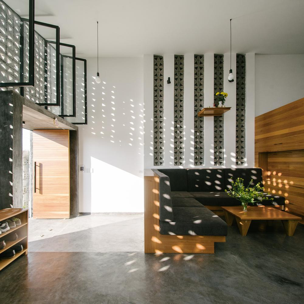 Bức tường này còn có tác dụng trang trí nội thất cho ngôi nhà, nhờ việc ánh sáng xuyên qua các khối gạch hoa văn tạo nên không gian ánh sáng đa chiều ở phòng khách. Vách kính phía sau có thể đóng mở dễ dàng để điều chỉnh lượng gió vào nhà theo mùa.