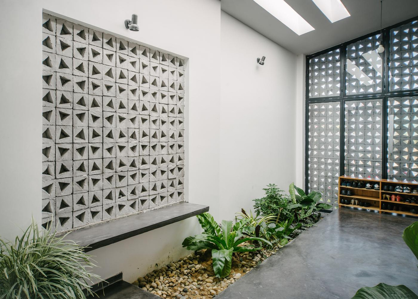 Ngôi nhà sử dụng màu trắng làm chủ đạo, trong khi đồ nội thất và sàn bê tông có màu xám giúp tôn lên màu sắc của các vật liệu gỗ và màu xanh tươi của cây cỏ trong nhà.