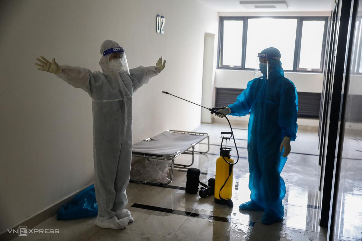Xong việc thăm khám, nhân viên y tế được đồng nghiệp phun khử khuẩn để tránh nguy cơ làm lây nhiễm.