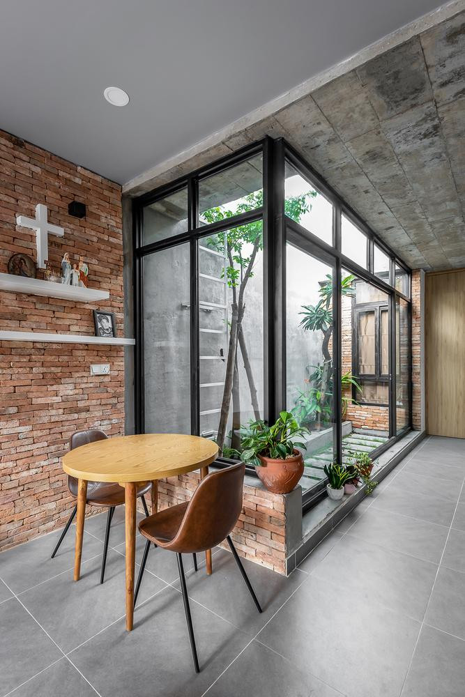 Sân giữa nằm cạnh không gian phòng bếp và phòng làm việc. Được ngăn cách bằng các bức tường kính trượt, giúp cho không gian trong nhà luôn tràn ngập ánh sáng và lưu thông không khí.