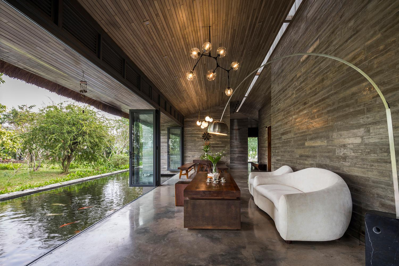 Hồ nước lớn chạy thẳng vào khoảng thông tầng ở hai bên ngôi nhà. Đây chính là yếu tố thân thiện với môi trường khi thiết kế cảnh quan và giảm nhiệt cho ngôi nhà trong ngày hè oi bức.