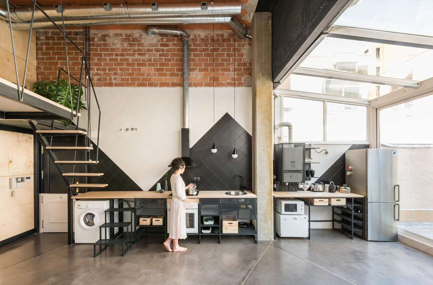 Khu vực chung của căn hộ, bao gồm nhà bếp thông ra một sân nhỏ ở hướng Đông giúp đón ánh sáng ban mai. Tại bếp, toàn bộ phần tường và mái được làm bằng kính trong để căn hộ đón được nhiều ánh sáng nhất.