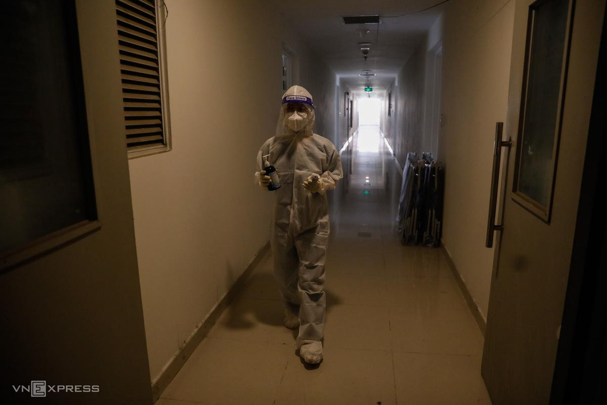 Trong ngày, các bác sĩ kiểm tra sức khỏe F0 một lần. Những bệnh nhân khi phát hiện các triệu chứng như ho, sốt cao, khó thở... sẽ gọi cho nhân viên y tế thông qua số điện thoại đường dây nóng. Cầm trên tay lọ nước rửa tay, thiết bị đo thân nhiệt và thuốc, bác sĩ Nguyễn Trần Anh Thư, từ Bệnh viện Phục hồi Chức Năng - Điều trị bệnh nghề nghiệp, được điều phối sang bệnh viện dã chiến, gõ cửa từng phòng bệnh nhân.