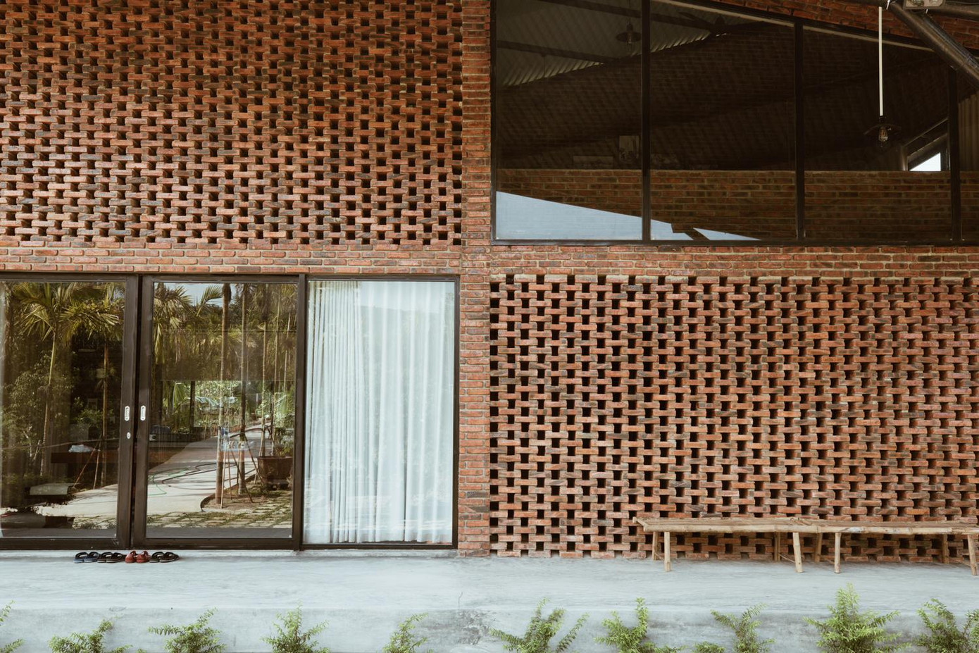 Vách ngăn của ngôi nhà là sự kết hợp giữa tường gạch và cửa kính. Trong khi các cửa kính thiết lập một kết nối trực quan giữa trong nhà và ngoài trời. Tường gạch có các lỗ đục giúp lưu thông không khí trong nhà.