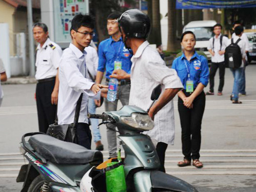 "Uống nước cho bớt căng thẳng mà thi tốt nghe con" - người cha dặn con trai. Ảnh: Tuấn Nguyễn.