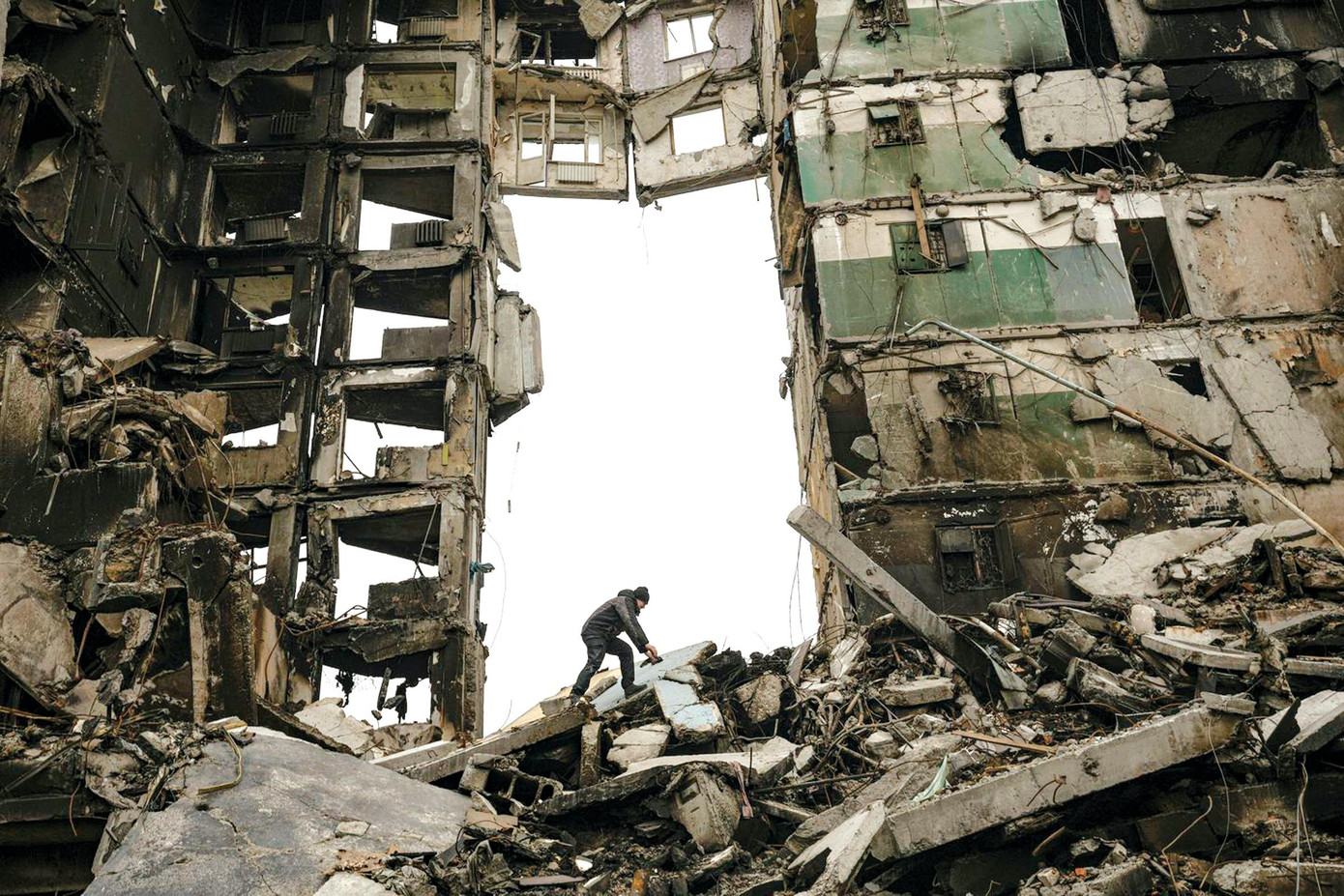 Một cư dân thành phố Bucha, Ukraine tìm kiếm đồ đạc trong tòa chung cư đổ nát do giao tranh Nga-Ukraine. Ảnh: AP