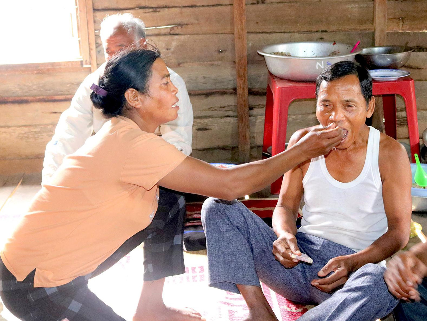 Chị Nay H’Đaih dùng tay bón cơm cho bố mình để thể hiện lòng thành kính