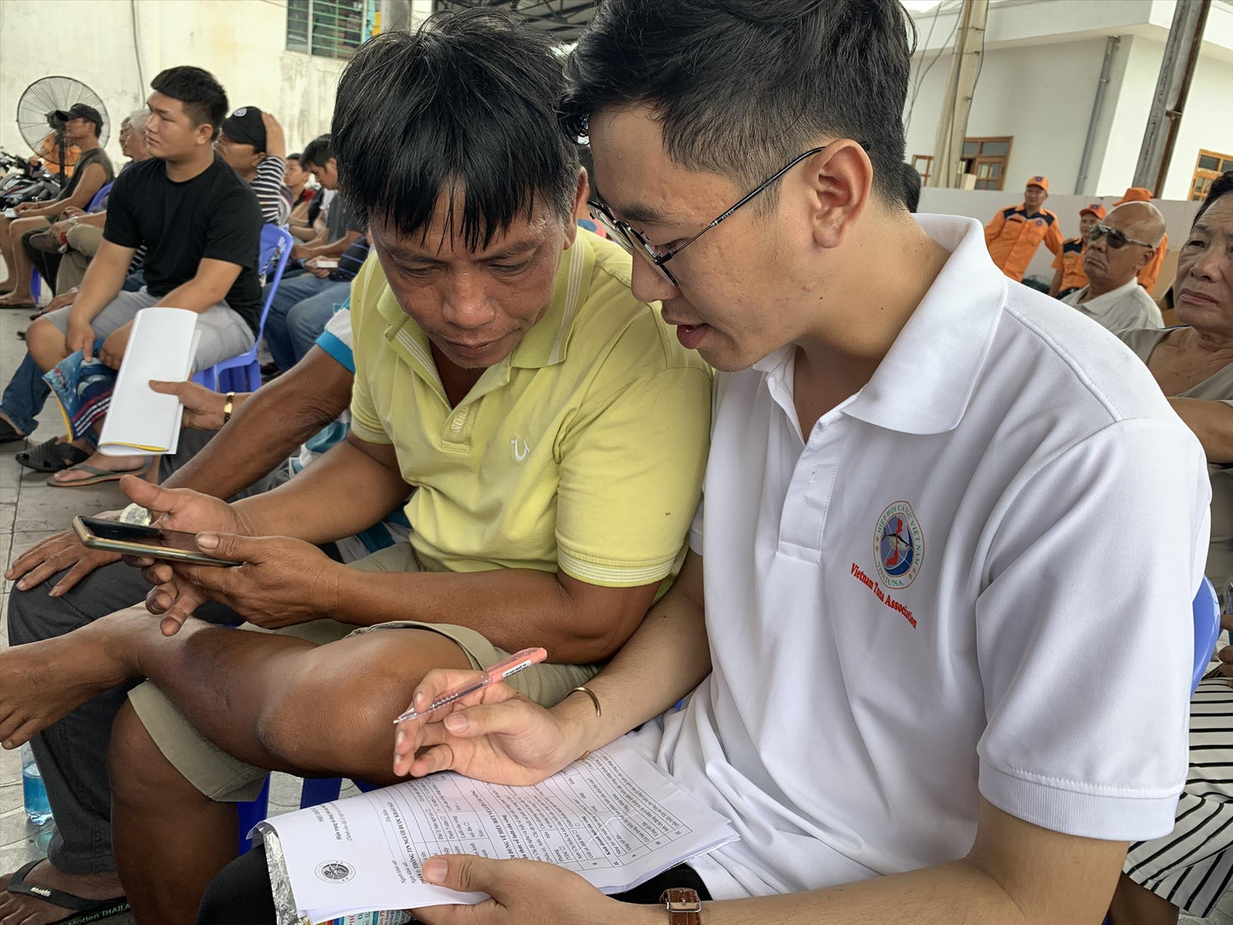 Huy Hoàng (bên phải) vận động ngư dân thay đổi nhận thức và tự giác tham gia BHYT. Ảnh: Thục Hiền Huy Hoàng (bên phải) vận động ngư dân thay đổi nhận thức và tự giác tham gia BHYT. Ảnh: Thục Hiền