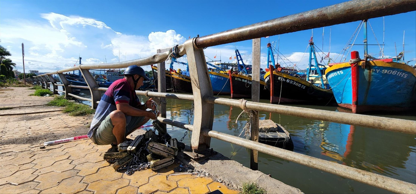 Trong khi chờ dầu về để ra khơi, anh Trương Văn Nhỏ, chủ tàu cá BTh-98386-TS mang bóng đèn ra thay cho tàu cá Trong khi chờ dầu về để ra khơi, anh Trương Văn Nhỏ, chủ tàu cá BTh-98386-TS mang bóng đèn ra thay cho tàu cá