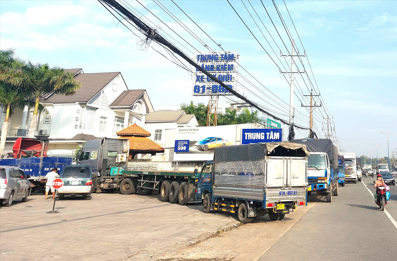 Xe đỗ tràn quốc lộ 13 ở Bình Dương chờ đăng kiểm. Ảnh: H.C Xe đỗ tràn quốc lộ 13 ở Bình Dương chờ đăng kiểm. Ảnh: H.C