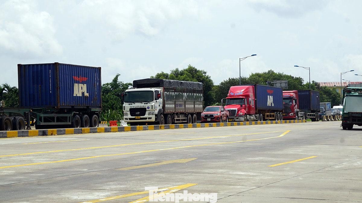 Container, xe cá nhân xếp hàng chờ tới lượt để qua trạm thu phí vào cao tốc Hà Nội - Hải Phòng trong ngày đầu thực hiện thu phí không dừng toàn tuyến.