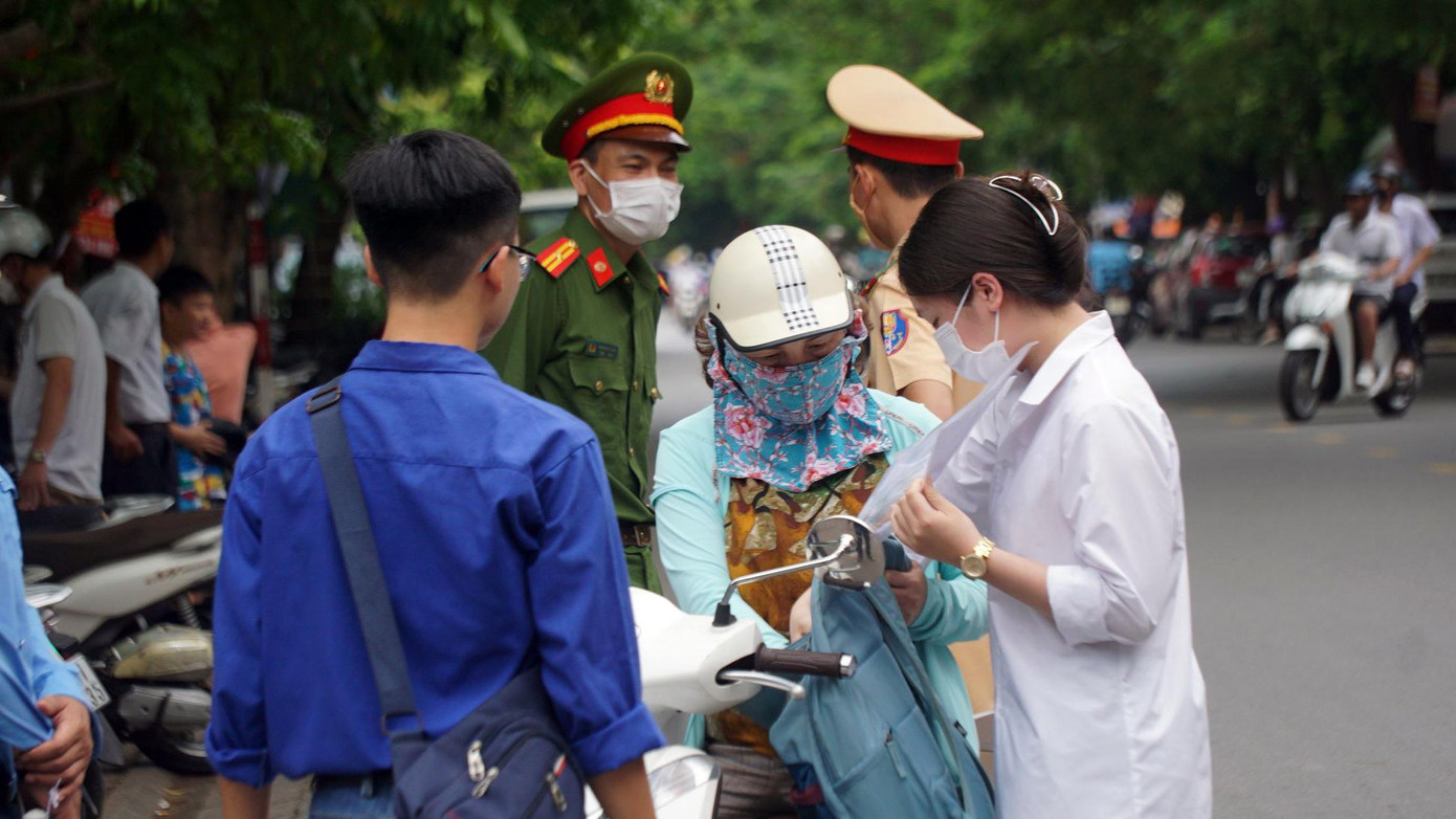 Một số thí sinh đến sát giờ thi được tình nguyện viên hỗ trợ để kịp vào phòng trước giờ phát đề.