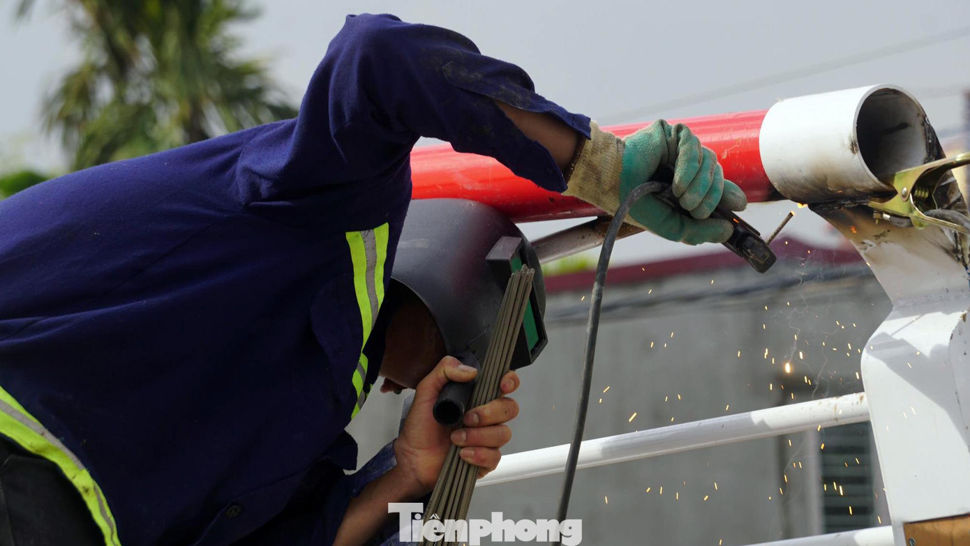Trong khi đó, nhiều công nhân khác kiểm tra các mối hàn kỹ thuật giữa các kết cấu thép dọc lan can.