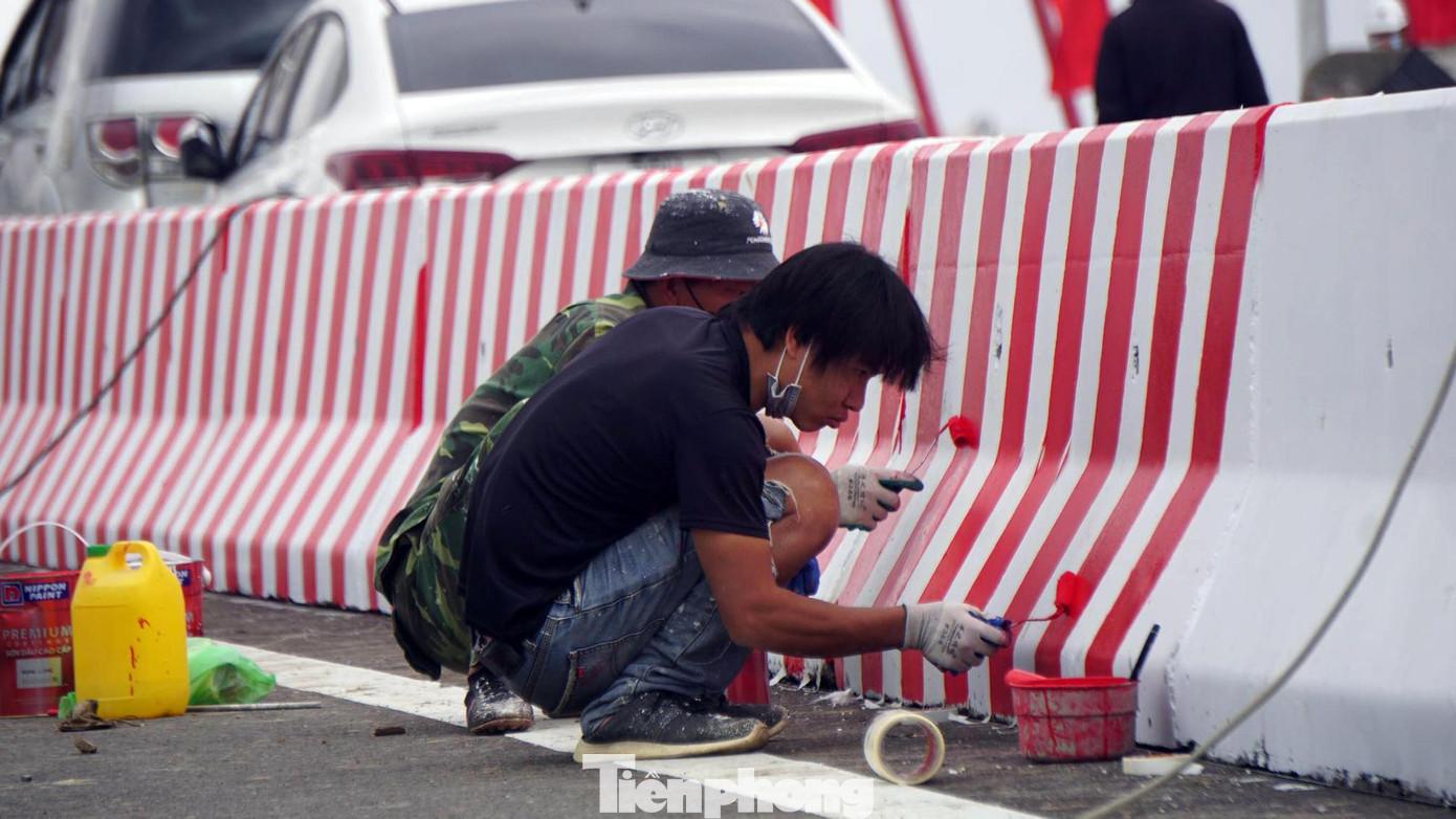 Một số công nhân trang trí, sơn màu cho dải phân cách giữa các làn xe.