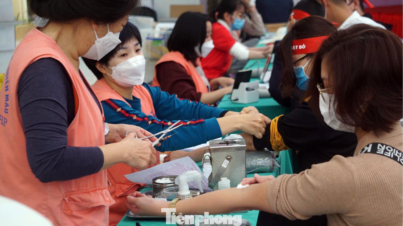 Nhân viên y tế kiểm tra sức khỏe trước khi tình nguyện viên hiến máu.