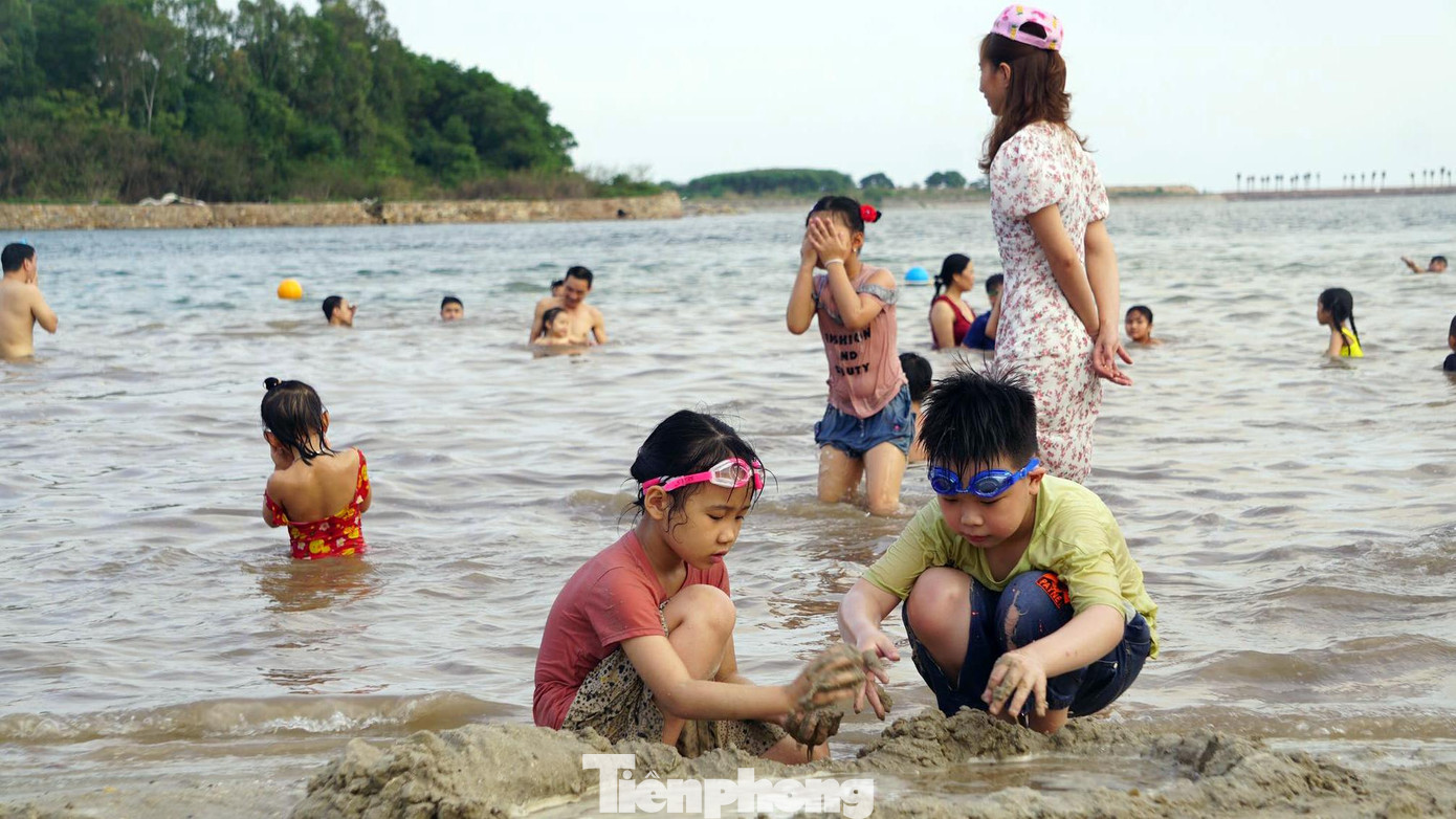 Bãi tắm mới thu hút hàng nghìn người dân đến vui chơi tắm mát. Nhiều em nhỏ thích thú nghịch cát, nô đùa trước biển.