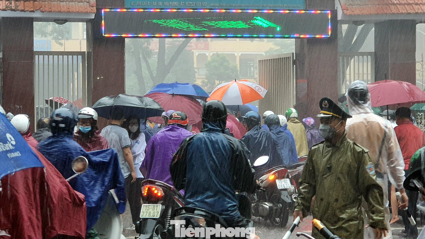 Hàng trăm phụ huynh lái xe máy đội mưa chờ đón con em sau khi kết thúc bài thi môn Ngữ Văn trước cổng Trường THPT Lê Quý Đôn. Mưa lớn kéo dài khiến tuyến phố Cát Bi ùn tắc, giao thông tê liệt khoảng 2 giờ.