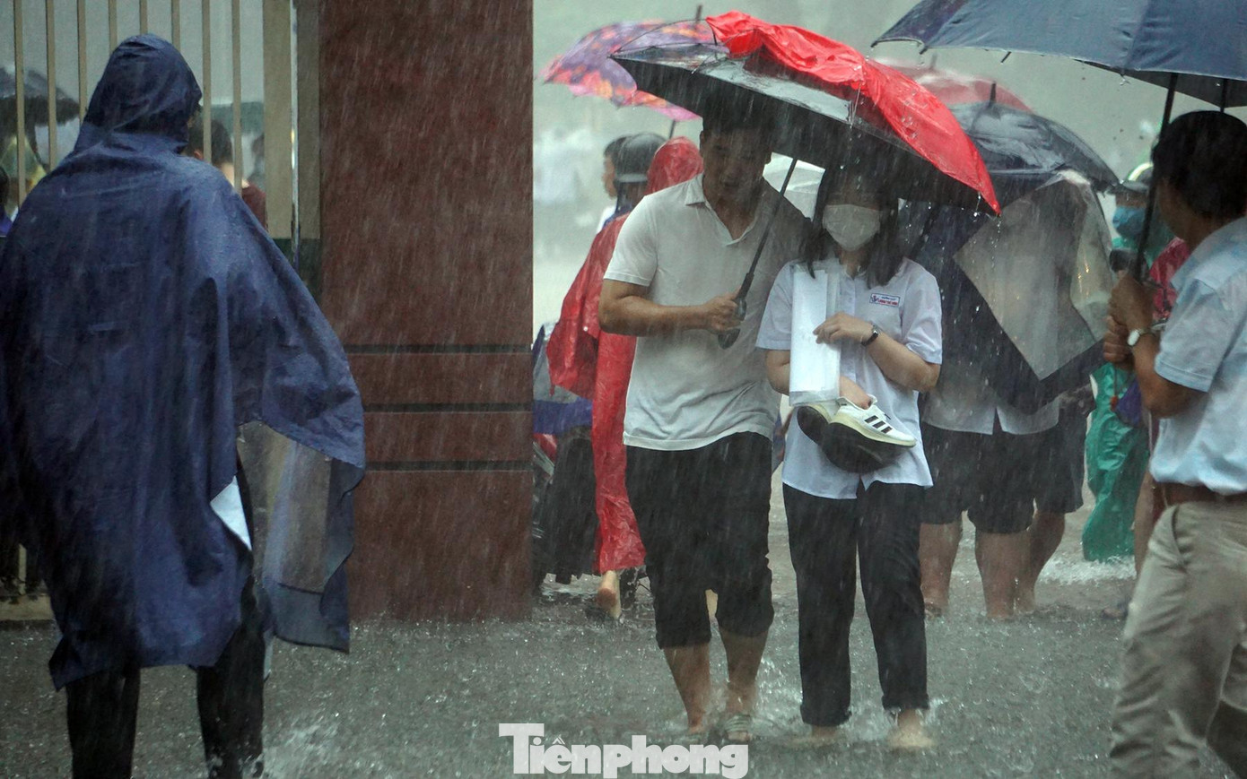 Do ùn tắc, giao thông tê liệt, nhiều phụ huynh đỗ ô tô từ xa rồi lấy ô vào cổng trường đón con em trở về nhà.