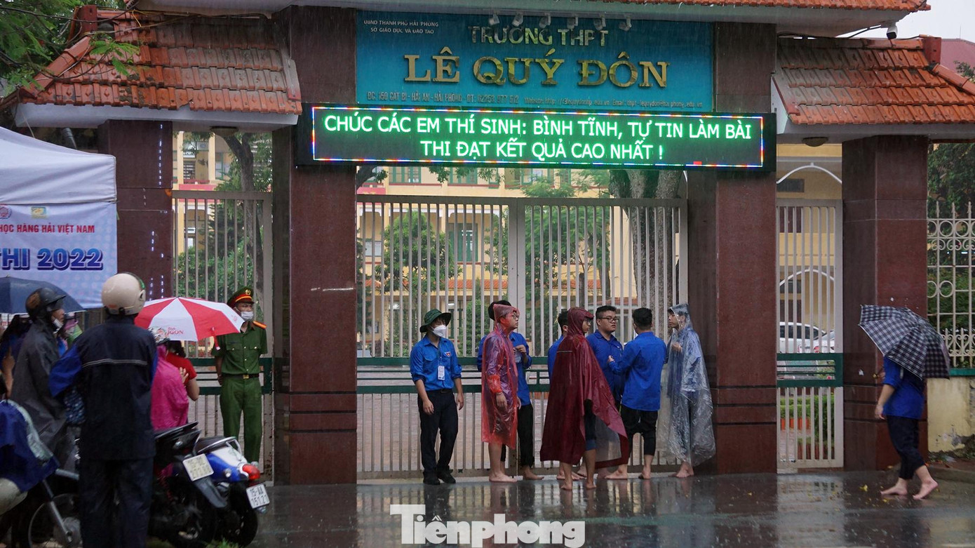 Hàng chục sinh viên tình nguyện cũng đội mưa cùng phụ huynh và lực lượng cảnh sát để hỗ trợ các thí sinh vượt vũ môn.