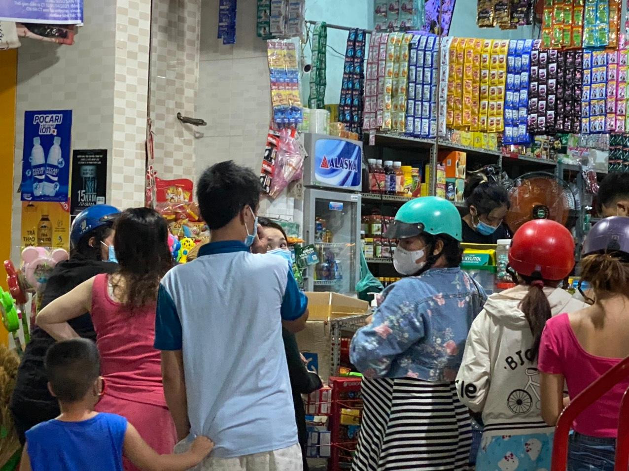 Người mua hàng ở quán tạp hóa xếp hàng, chen chúc nhau. Ảnh: Thanh Phong.