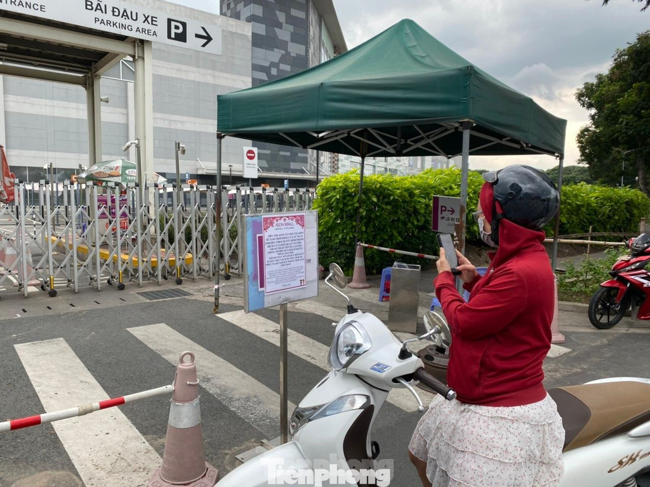 Người dân đến mua sắm nhưng siêu thị đóng cửa, đứng chụp bảng thông báo của siêu thị Aeon Mall Tân Phú Celadon.