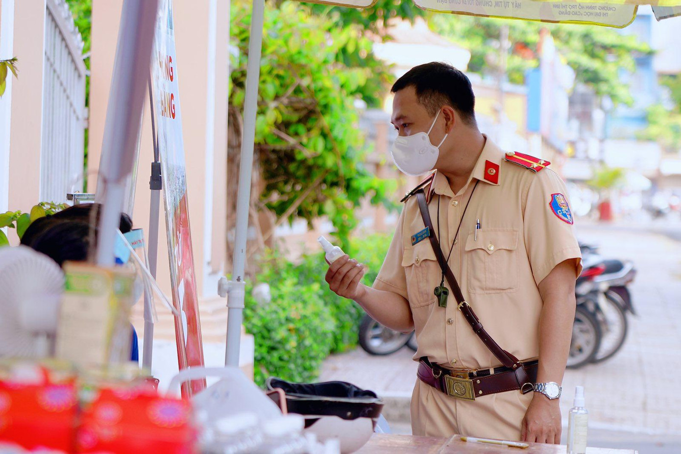 Cảnh sát giao thông nhận nước rửa tay sát khuẩn do trường ĐH Quốc tế Hồng Bàng gửi tặng.