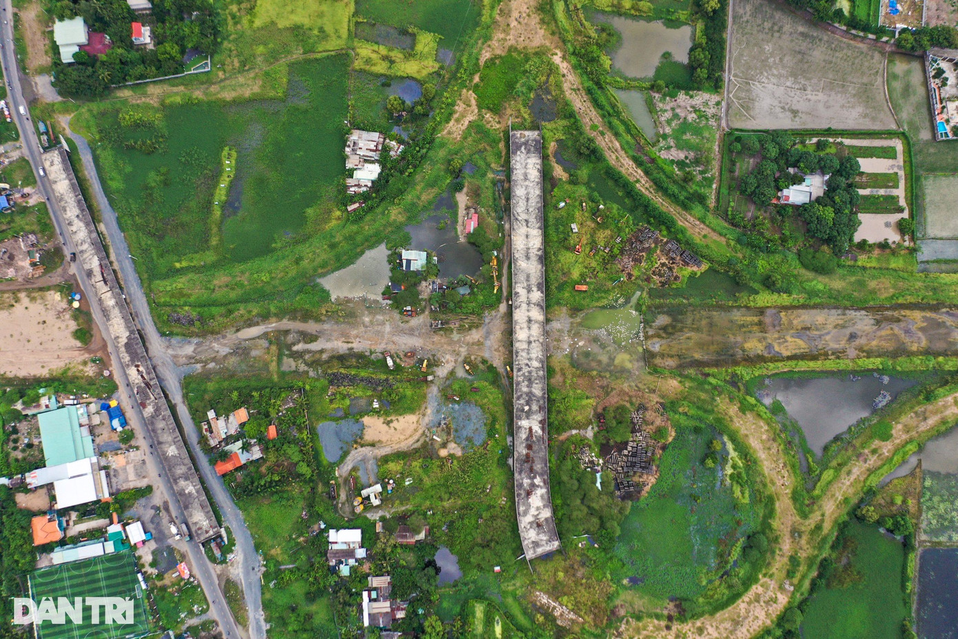 Hai cầu vượt qua cao tốc tại nút giao này nằm trơ trọi, bê tông xám xịt vì phơi nắng mưa nhiều năm qua. Vật liệu nằm ngổn ngang khắp nơi trên đại công trường. Hai cầu vượt qua cao tốc tại nút giao này nằm trơ trọi, bê tông xám xịt vì phơi nắng mưa nhiều năm qua. Vật liệu nằm ngổn ngang khắp nơi trên đại công trường.