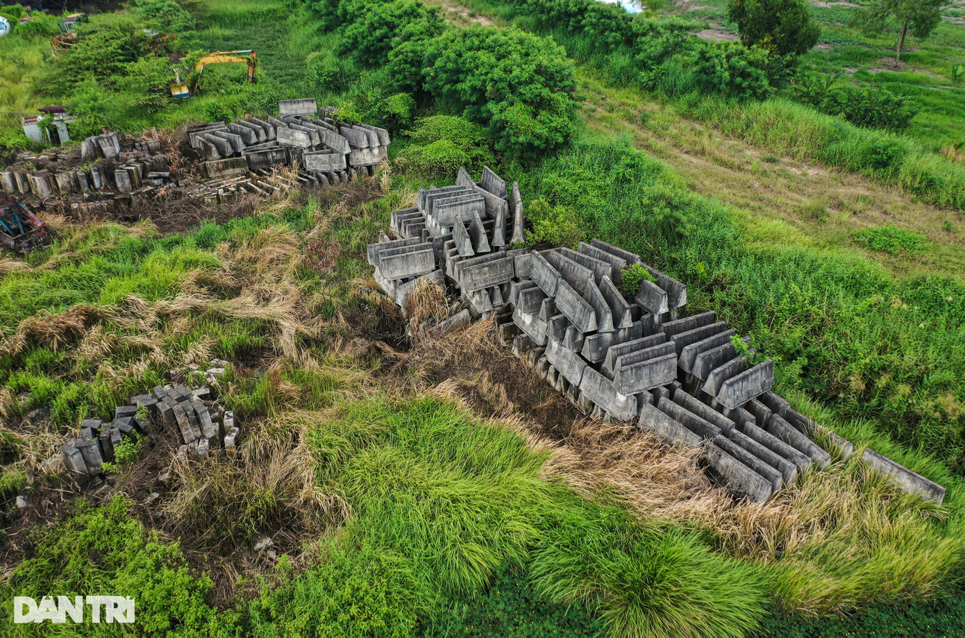 Nằm giữa cánh đồng cỏ rập rạp là hàng nghìn khối bê tông được đúc sẵn để dùng làm dải phân cách làn đường cao tốc, được chất thành nhiều lớp giữa công trường. Nằm giữa cánh đồng cỏ rập rạp là hàng nghìn khối bê tông được đúc sẵn để dùng làm dải phân cách làn đường cao tốc, được chất thành nhiều lớp giữa công trường.
