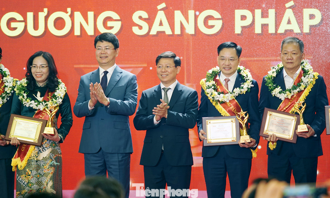 Ông Trần Thanh Lâm, Phó Trưởng ban Tuyên giáo Trung ương (thứ ba từ phải sang) và Thứ trưởng Bộ Tư pháp Nguyễn Thanh Tịnh trao kỷ niệm chương, giấy chứng nhận và tặng hoa chúc mừng các cá nhân được vinh danh "Gương sáng pháp luật". Ảnh: Thanh Hà