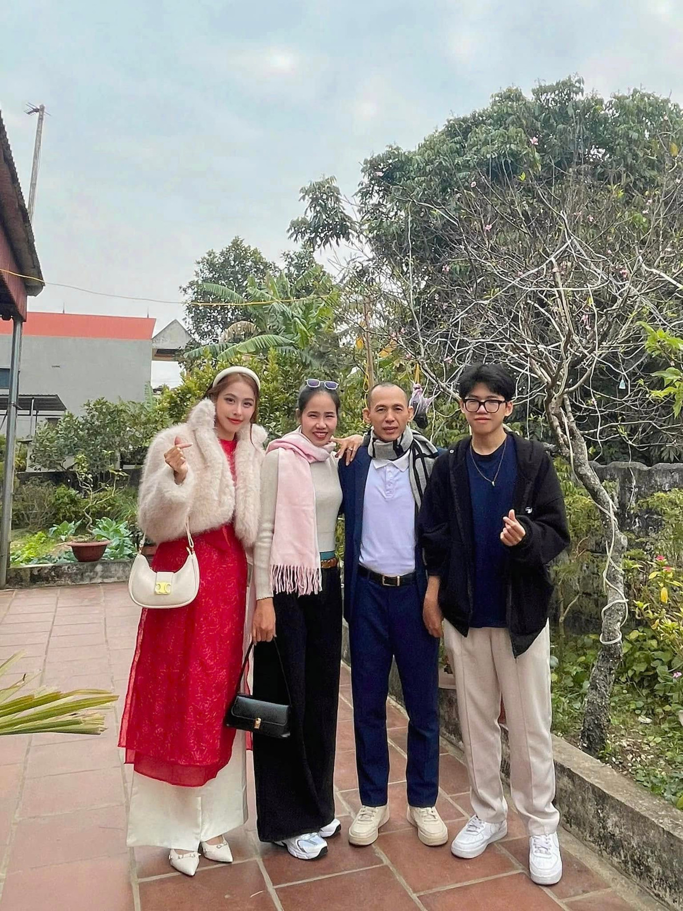 Á hậu Ngọc Hằng mặc áo dài đỏ khi đi chúc Tết họ hàng trong ngày mùng 1 Tết.