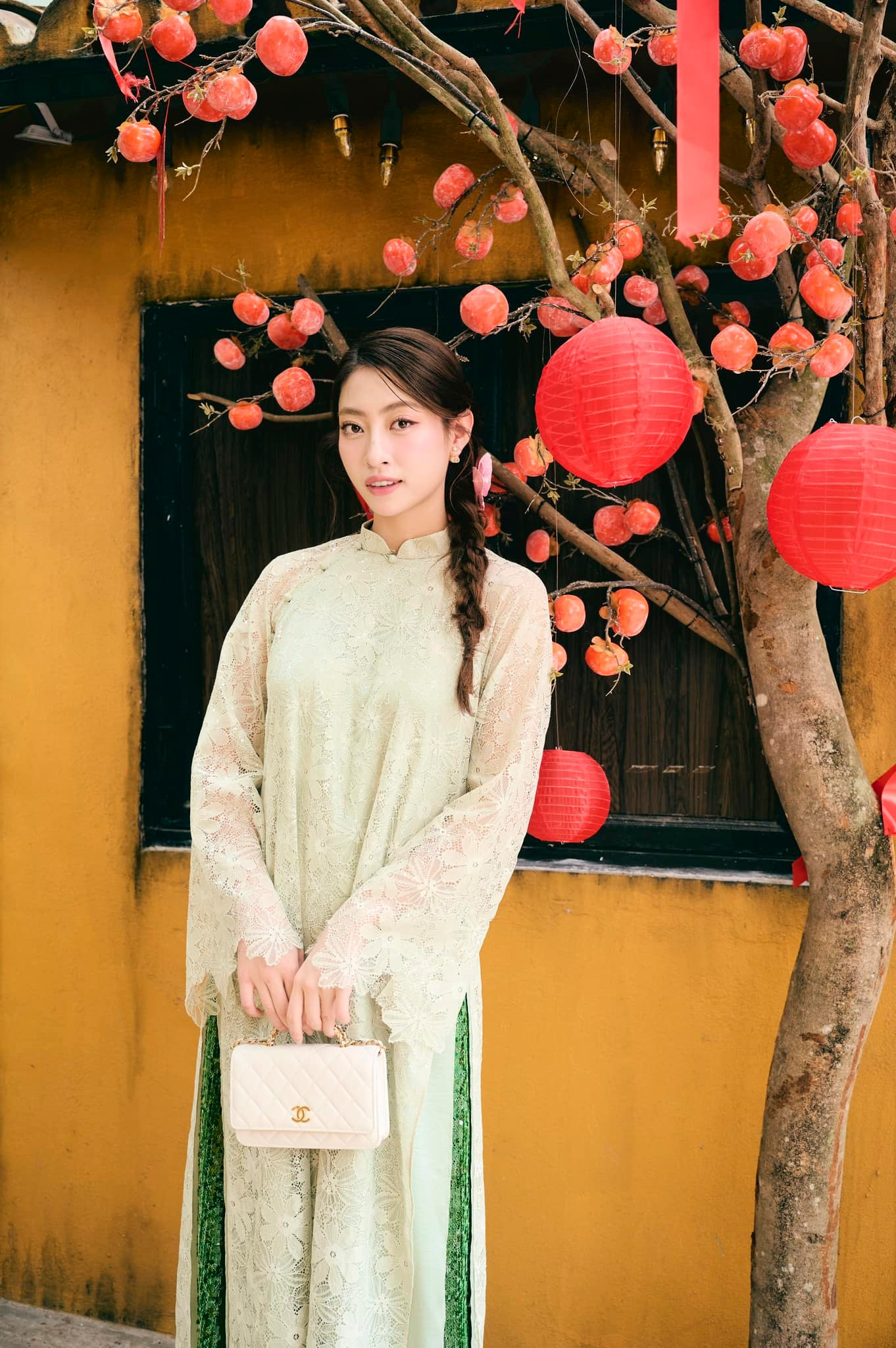 Hoa hậu Lương Thùy Linh mặc áo dài ren màu xanh đi vãn cảnh chùa ở quê hương Cao Bằng trong ngày Mùng 3 Tết.