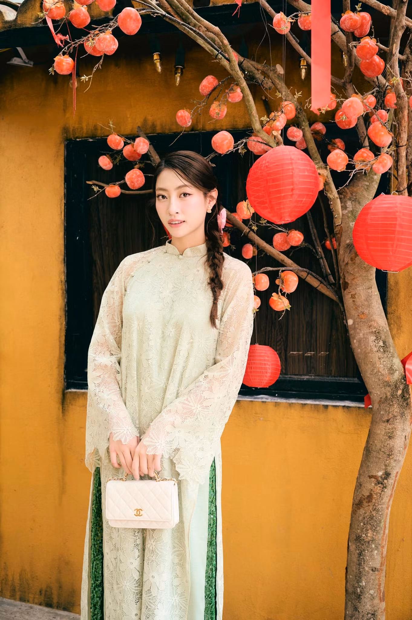 Hoa hậu Lương Thùy Linh mặc áo dài ren màu xanh đi vãn cảnh chùa ở quê hương Cao Bằng trong ngày Mùng 3 Tết.